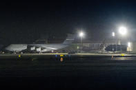 A charter flight transporting passengers from the quarantined Diamond Princess cruise ship moves behind military airplanes after it arrived at Travis Air Force Base in Fairfield, Calif., Sunday, Feb. 16, 2020. (AP Photo/Hector Amezcua)