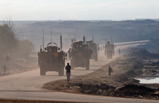 US military vehicles drive along a highway linking Kabul to Bagram, on March 25, 2012.Afghan President Hamid Karzai said Thursday that he could allow the United States to keep nine military bases in the country as part of negotiations over a long-term security pact with Washington