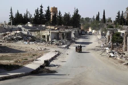 Vehicles drive past damaged buildings in al-Rai town, northern Aleppo countryside, Syria October 2, 2016. REUTERS/Khalil Ashawi