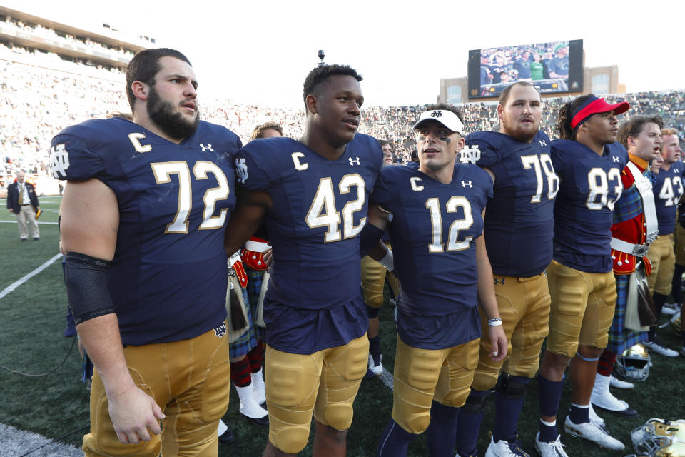 Notre Dame's Robert Hainsey (72), Julian Okwara (42), Ian Book (12) and Tommy Kraemer (78) sing after beating New Mexico 66-14 after an NCAA college football game in South Bend, Ind., Saturday, Sept. 14, 2019. (AP Photo/Paul Sancya)