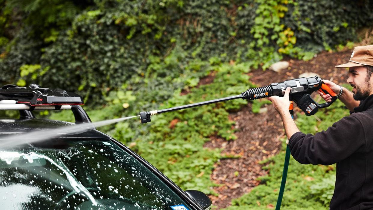 a person cleaning their car with a pressure washer