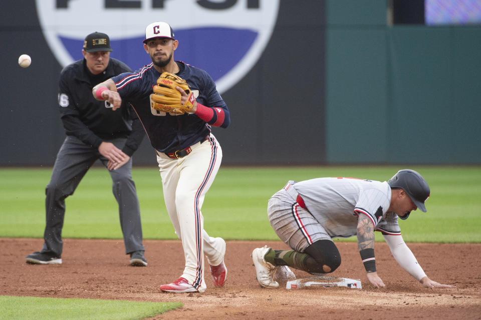 Cleveland Guardians' Gabriel Arias, front left, forces out Minnesota Twins' Jose Miranda at second base and completes a double play by throwing out Willi Castro at first during the third inning of a baseball game in Cleveland, Friday, May 17, 2024. Umpire Lance Barrett, back left, looks on. (AP Photo/Phil Long)