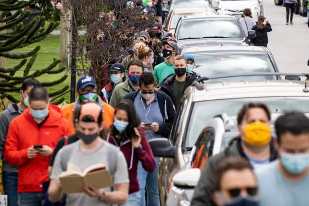 People are pictured lined up to receive their COVID-19 vaccine during a walk-in clinic at the Poirier Forum in Coquitlam, British Columbia on Tuesday, April 27, 2021.  (Ben Nelms/CBC - image credit)