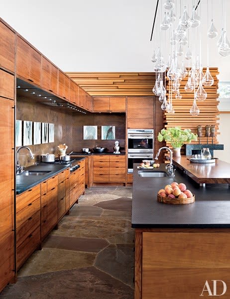 Architect Peter Gluck and his son, Thomas, designed this boldly contemporary retreat in North Carolina’s Blue Ridge Mountains featuring a kitchen clad in black-walnut-veneer cabinetry and a copper backsplash.