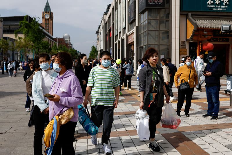 FILE PHOTO: People walk at a shopping street in Beijing