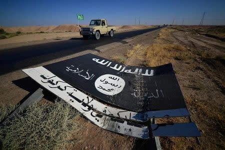A black sign belonging to Islamic State militants is seen on the road in Al-Al-Fateha military airport south of Hawija, Iraq, October 2, 2017. REUTERS/Stringer