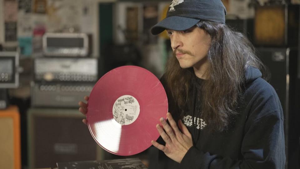 Josh Wickins of Wormwood Records in Ajax, Ont. holds up a new recording by the hardcore band Street Justice pressed on Eco Mix vinyl on December 19, 2023. 