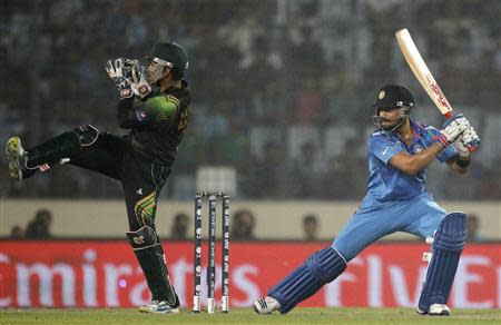 India's Virat Kohli (R) plays a ball as Pakistan's wicketkeeper Kamran Akmal tries to catch during their ICC Twenty20 World Cup cricket match at the Sher-E-Bangla National Cricket Stadium in Dhaka March 21, 2014. REUTERS/Andrew Biraj