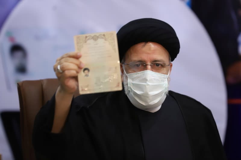 Ebrahim Raisi, Chief Justice of Iran, shows his identification document as he registers as a candidate for the presidential election at the Interior Ministry, in Tehran