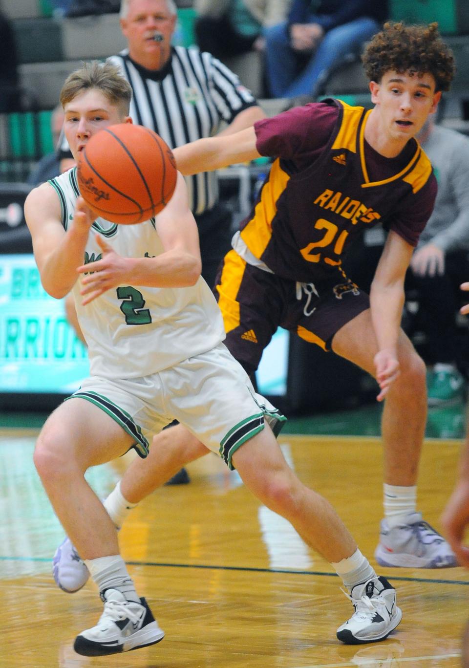 West Branch's Joey Jackson passes the ball after driving past South Range defender Logan Baxter in a non-conference game Tuesday, December 6, 2022 at the West Branch Field House.