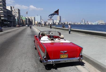 Tourists ride a U.S.-made 1957 Chevrolet Bel-Air convertible car on Havana's seafront boulevard 'El Malecon' May 21, 2013. REUTERS/Desmond Boylan