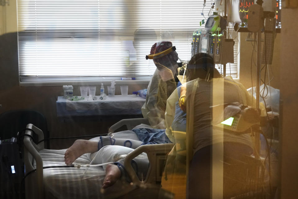 FILE - In this Aug. 18, 2021, file photo, medical staff tend to a patient with coronavirus, on a COVID-19 ward inside the Willis-Knighton Medical Center in Shreveport, La. COVID-19 deaths and cases in the U.S. have climbed back to where they were over the winter, wiping out months of progress and potentially bolstering President Joe Biden’s case for sweeping new vaccination requirements. (AP Photo/Gerald Herbert, File)