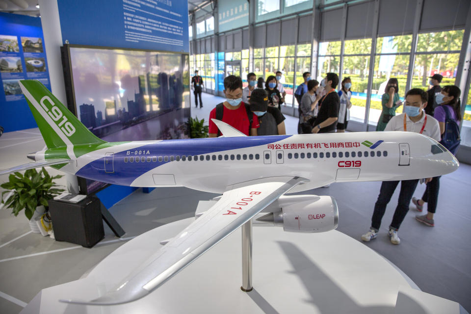 People look at a model of China's domestically-made C919 passenger jet at the China International Fair for Trade in Services (CIFTIS) in Beijing, Saturday, Sept. 5, 2020. Chinese leaders are shifting focus from the coronavirus back to long-term goals of making China a technology leader at this year's highest-profile political event, the meeting of its ceremonial legislature, amid tension with Washington and Europe over trade, Hong Kong and human rights. (AP Photo/Mark Schiefelbein)