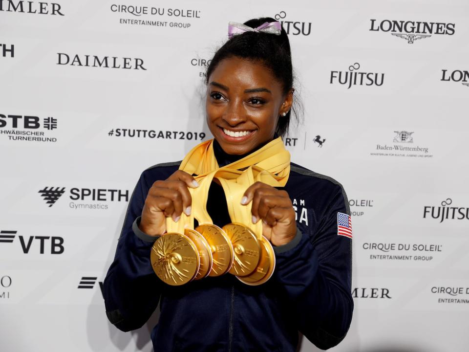 Simone Biles poses with some of her World Championship gold medals.