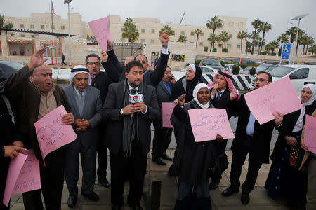 Jordanian Members of Parliament chant slogans and hold signs during a sit-in against a potential announcement by the U.S. to move its embassy to Jerusalem, in front of the U.S. Embassy in Amman, Jordan, December 6, 2017. The sign (R) reads: "We denounce and condemn the U.S. administration's reckless decision." REUTERS/Muhammad Hamed
