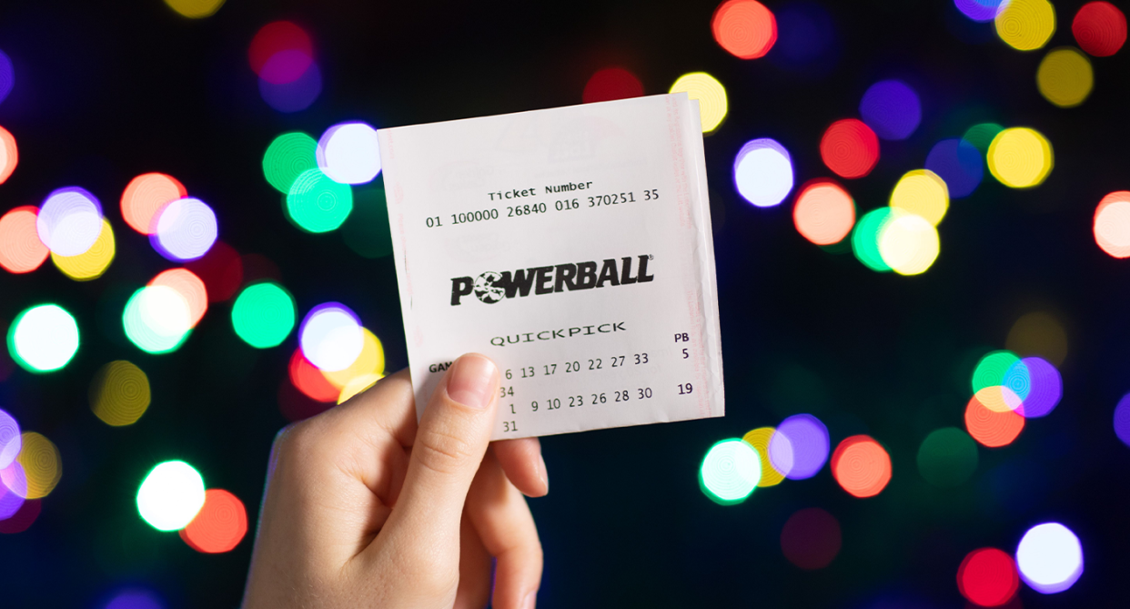 A Powerball ticket is seen behind in front a set of lights. 