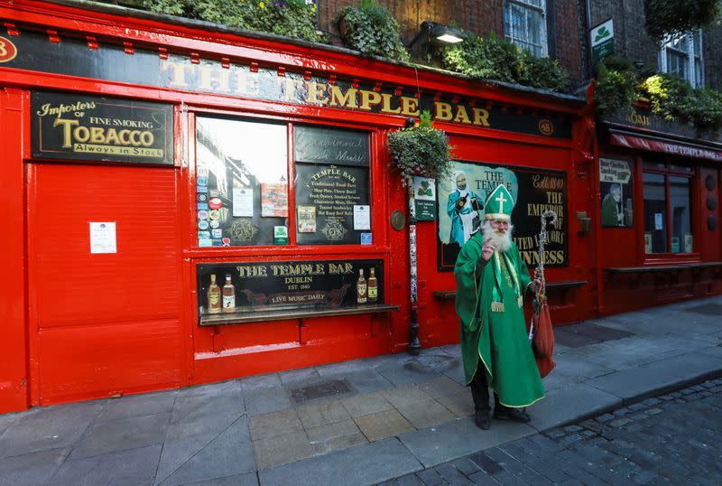 A man dressed up as Saint Patrick is pictured outside The Temple Bar pub, as bars across Ireland are to close voluntarily to curb the spread of coronavirus in Dublin