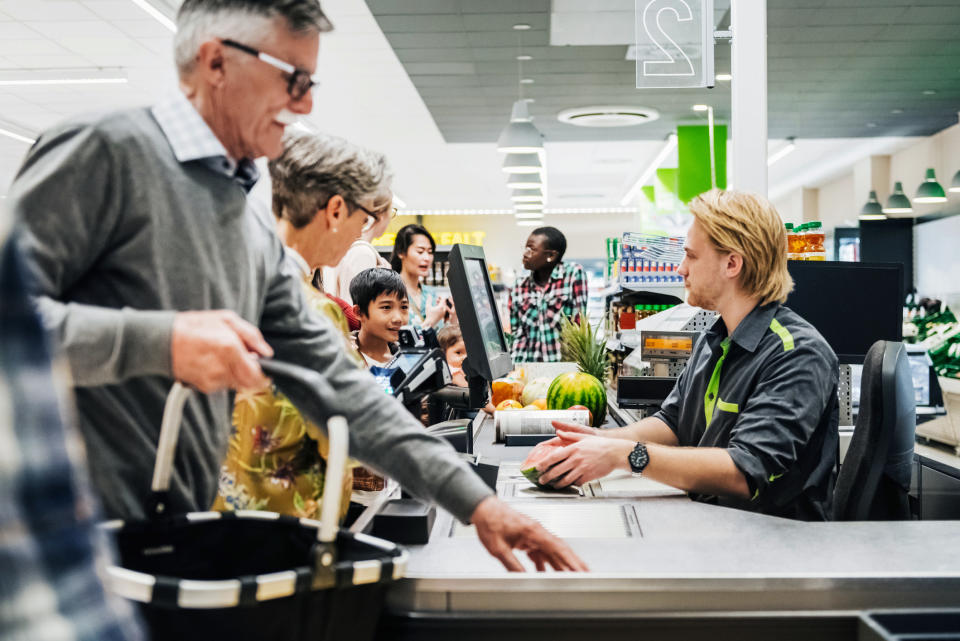 A cashier sitting and ringing people up at a grocery store