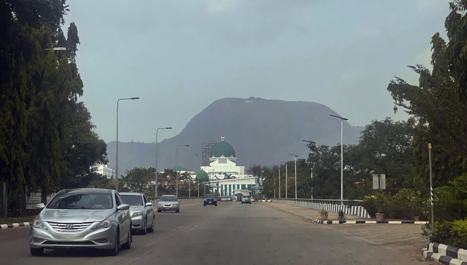 Cars drive past the National Assembly building in Abuja, Nigeria, Thursday, Nov. 2, 2023. Nigeria's lawmakers on Thursday approved the new government's first supplemental budget, which includes huge allocations for SUVs and houses for the president, his wife and other public officials, sparking anger and criticism from citizens in one of the world's poorest countries. (AP Photo/Chinedu Asadu)