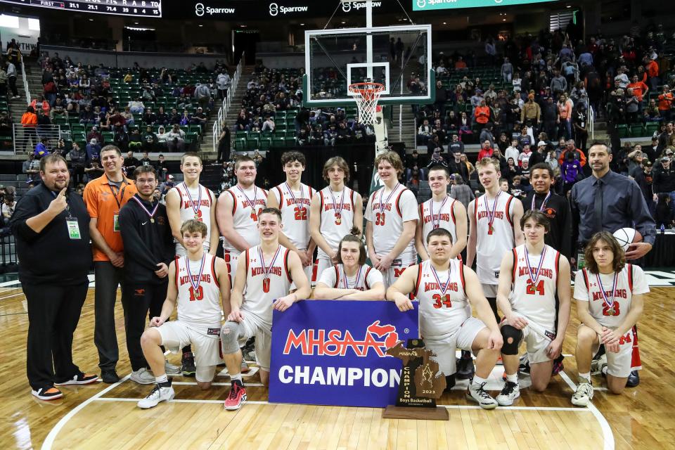 Munising players and coaches celebrate 39-37 win over Wyoming Tri-unity Christian at the MHSAA boys Division 4 final at Breslin Center in East Lansing on Saturday, March 25, 2023.
