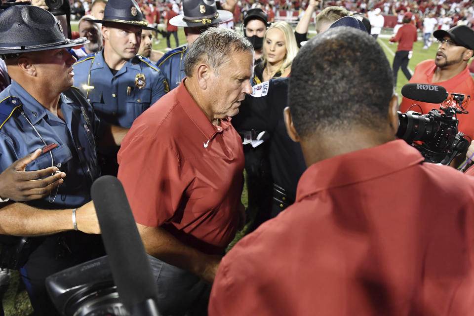 Arkansas coach Sam Pittman is escorted off the field after the team's win over Texas in an NCAA college football game Saturday, Sept. 11, 2021, in Fayetteville, Ark. (AP Photo/Michael Woods)
