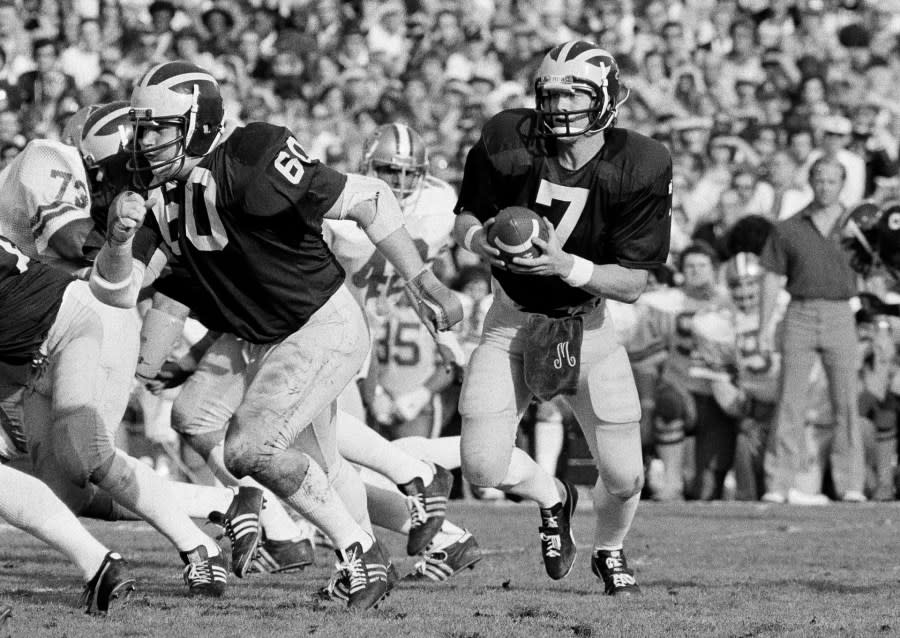 Rick Leach scrambles with the ball as the offensive line works to protect him.