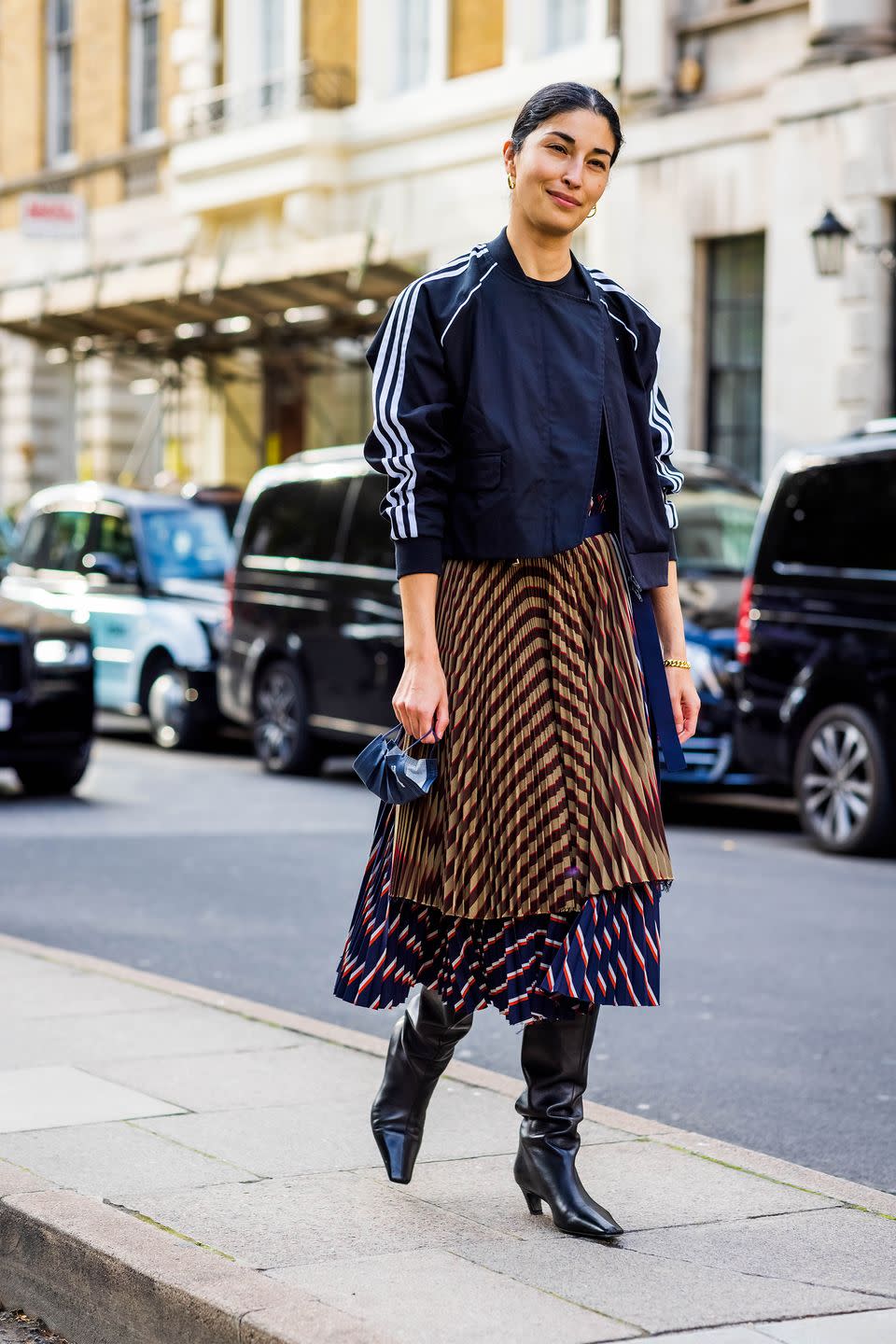 <p>Caroline pairs her track jacket with a striped skirt.</p>