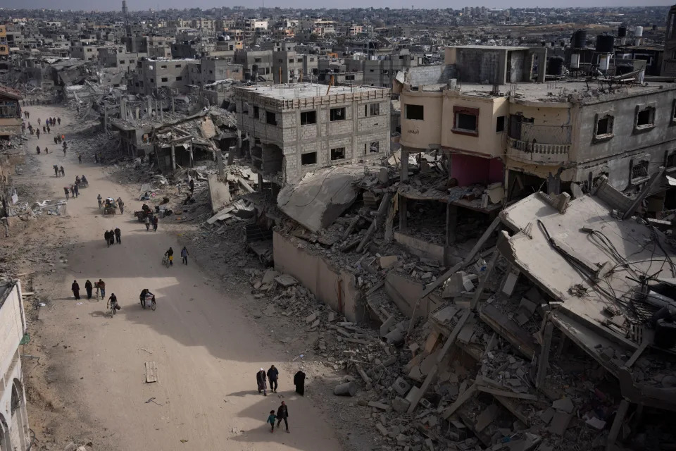 Palestinians walk through the destruction in the wake of an Israeli air and ground offensive in Khan Younis on April 8, 2024.