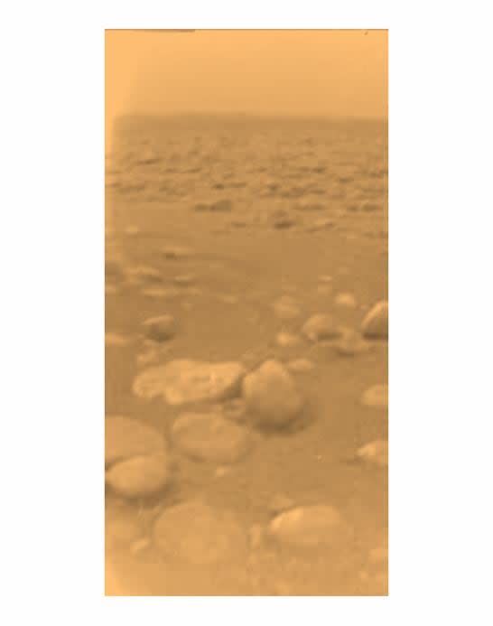 This image was returned on January 14, 2005 by ESA's Huygens probe during its successful descent to Titan.  This is the color rendering, which, after processing to add reflectance spectra data, gives a better indication of the actual color of the surface.  Initially thought to be rocks or ice blocks, they are more pebble sized.  The two rocky objects just below the center of the image have a diameter of about 15 centimeters (left) and 4 centimeters (center), respectively, at a distance of about 85 centimeters from Huygens.  The surface is darker than originally expected and consists of a mixture of water and hydrocarbon ice.  There is also evidence of erosion at the base of these features, indicating possible river activity. 