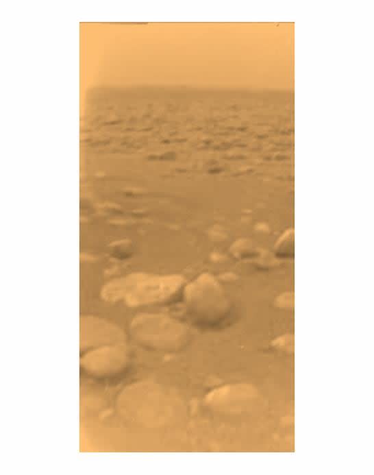 This image was returned on 14 January 2005, by ESA's Huygens probe during its landing on Titan.  This is the color perception, after processing to add reflection spectrum data, it gives a better representation of the actual color of the surface.  At first thought to be rocks or blocks of ice, they are larger than a pebble.  The two rocky objects just below the center of the image are about 15 centimeters (left) and 4 centimeters (centre) across respectively, about 85 centimeters from Huygens.  The surface is darker than first expected, consisting of a mixture of water and hydrocarbon ice.  There is also evidence of erosion at the base of these objects, indicating possible fluvial activity. 