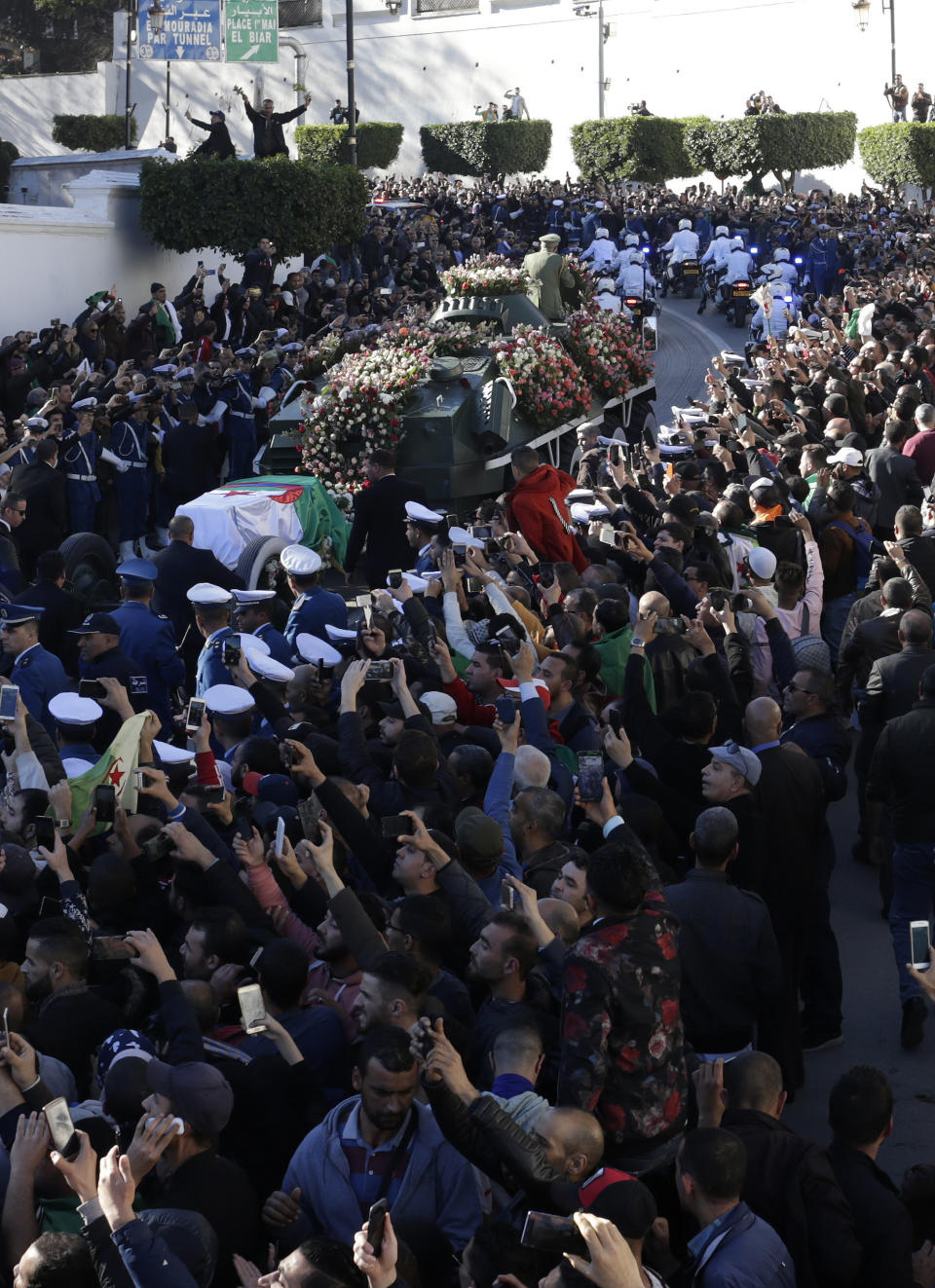 People gather during the funeral Gen. Ahmed Gaid Salah, in Algiers, Algeria, Wednesday, Dec. 25, 2019. Algeria is holding an elaborate military funeral for the general who was the de facto ruler of the gas-rich country amid political turmoil throughout this year. (AP Photo/Toufik Doudou)