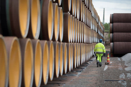 FILE PHOTO: A man walks by a stack of North Stream 2 pipes in Kotka, Finland, June 8, 2017. REUTERS/Axel Schmidt/File Photo