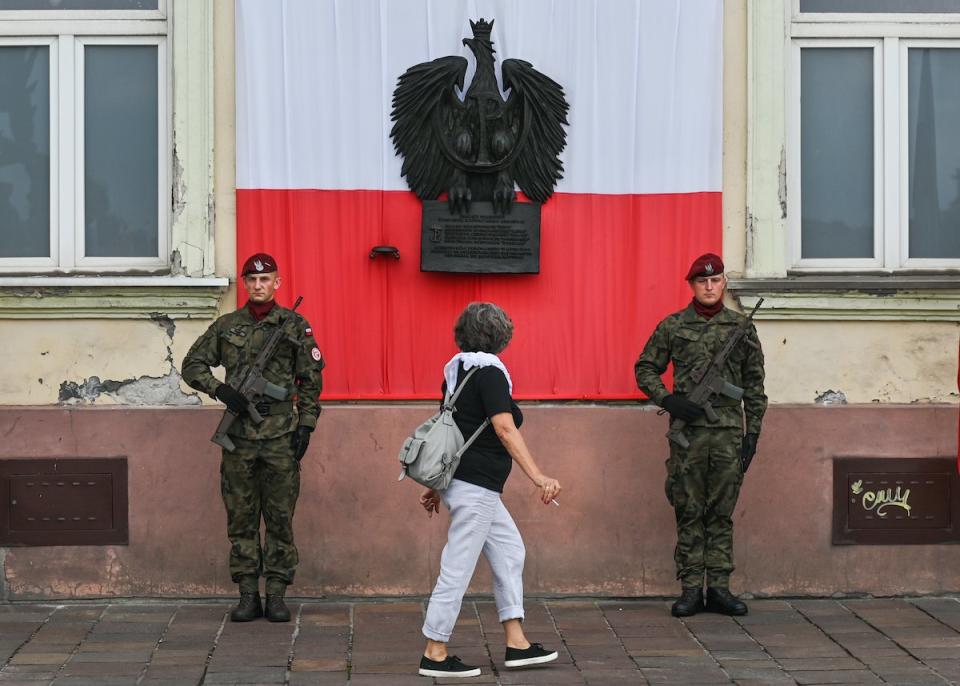 Eine Frau läuft an zwei Soldaten in Krakau vorbei. Polens Armee entwickelt sich zur wichtigsten nicht-nuklearen Streitmacht innerhalb der Nato. - Copyright: Artur Widak/NurPhoto via Getty Images