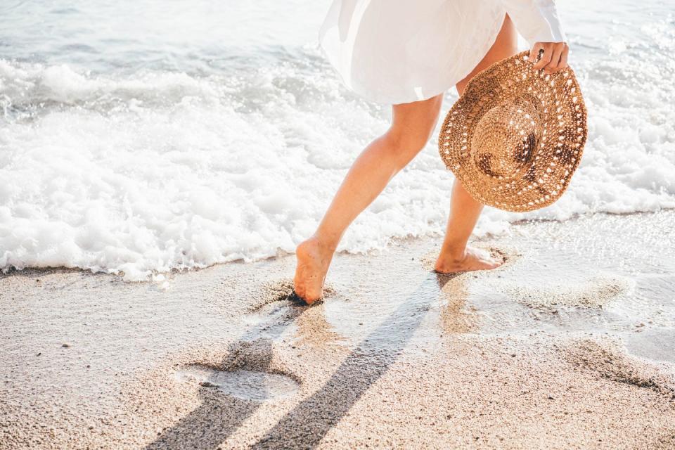 woman walking on the beach at sunset