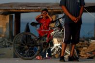 FILE PHOTO: A child is seen outside a new temporary camp for migrants and refugees