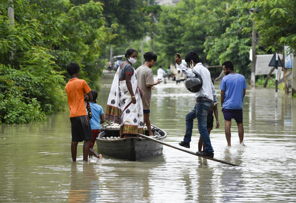 Villager uses a country boat to move across a flooded locality in Kamrup district of Assam, in India on 14 July 2020. (Photo by David Talukdar/NurPhoto via Getty Images)