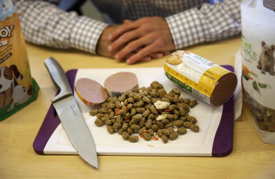 In this Tuesday, Oct. 1, 2013, photo, Freshpet co-founder and president Scott Morris talks with an Associated Press reporter over a display of the company's pet food in Bethlehem, Pa. “People are trying to eat healthier, less processed, simpler foods, and I think they are applying that logic when they’re making pet food decisions,” said Morris. (AP Photo/Matt Slocum)