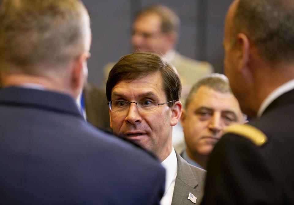 U.S. Secretary for Defense Mark Esper, center, speaks with military representatives as he attends a meeting of the North Atlantic Council at NATO headquarters in Brussels, Thursday, Feb. 13, 2020. NATO ministers, in a second day of meetings, will discuss building stability in the Middle East, the Alliance's support for Afghanistan and challenges posed by Russia's missile systems. (AP Photo/Virginia Mayo)