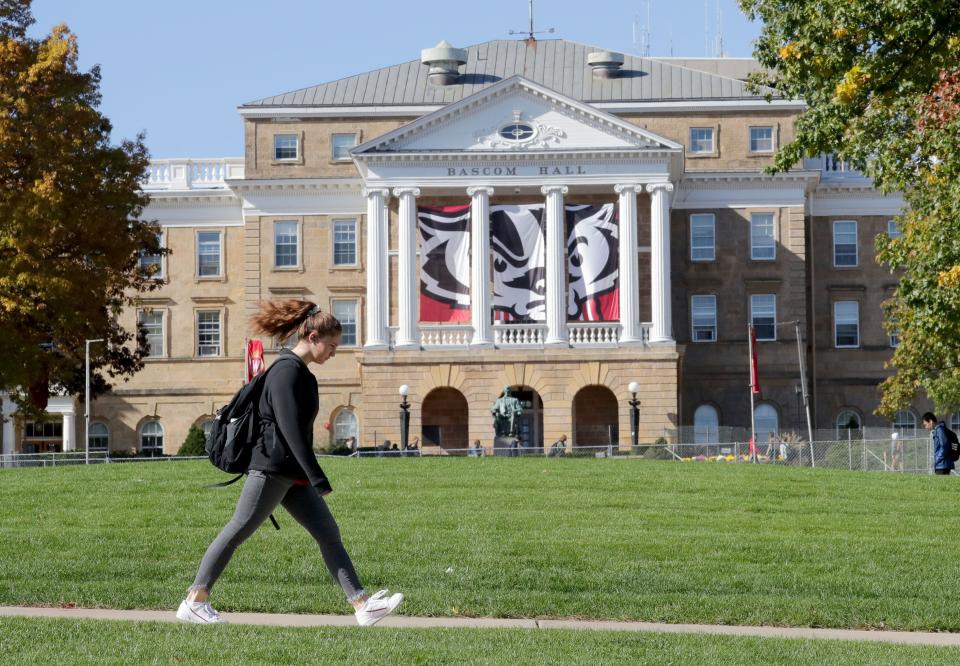 A students walks to classes on campus past Bascom Hall at the University of Wisconsin-Madison on Oct. 23.