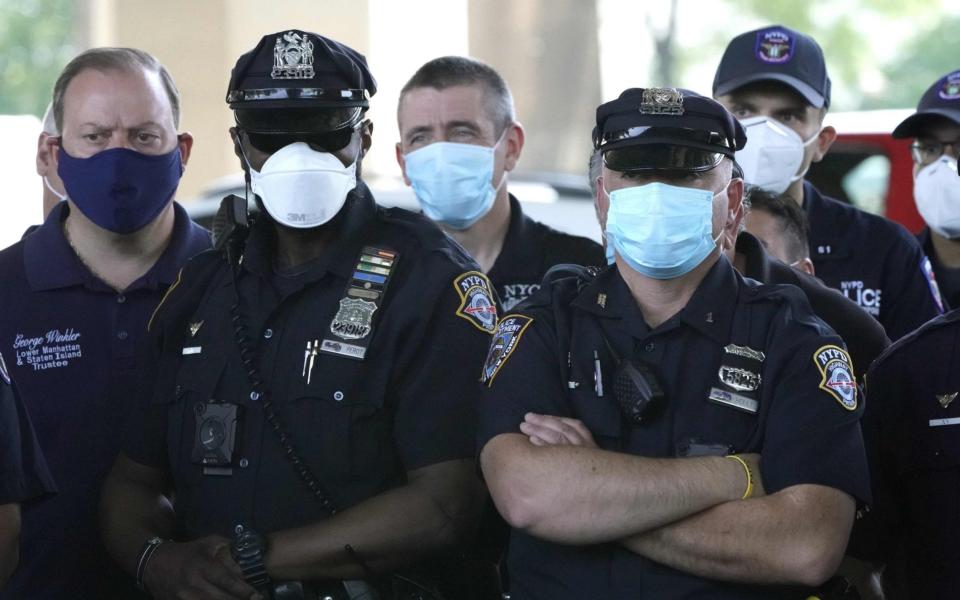 NYPD Police officers listen as Police Benevolent Association of the City of New York President Pat Lynch holds a news conference to address the "current anti-law enforcement environment." - AFP