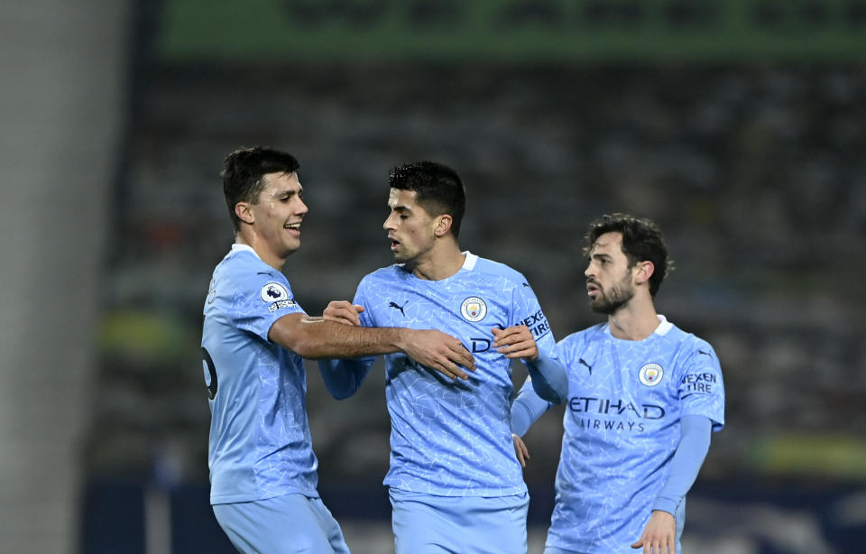 Manchester City's Joao Cancelo, centre, celebrates with teammates after scoring his side's second goal during the English Premier League soccer match between West Bromwich Albion and Manchester City at the Hawthorns stadium in West Bromwich, England, Tuesday, Jan. 26, 2021. (Laurence Griffiths/Pool via AP)