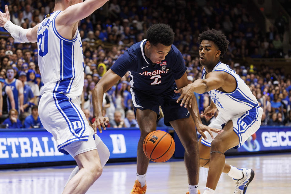 Virginia's Reece Beekman (2) loses the ball between Duke's Sean Stewart (13) and Duke's Kyle Filipowski (30) during the first half of an NCAA college basketball game in Durham, N.C., Saturday, Mar. 2, 2024. (AP Photo/Ben McKeown)