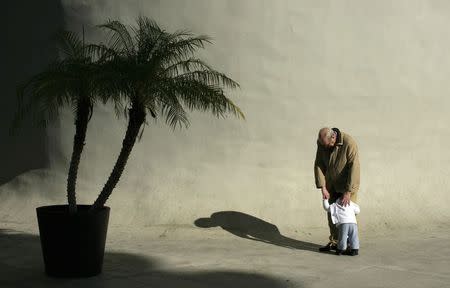 An elderly man hugs a boy in the Andalusian capital of Seville in this January 18, 2012 file photo. REUTERS/Marcelo Del Pozo/Files