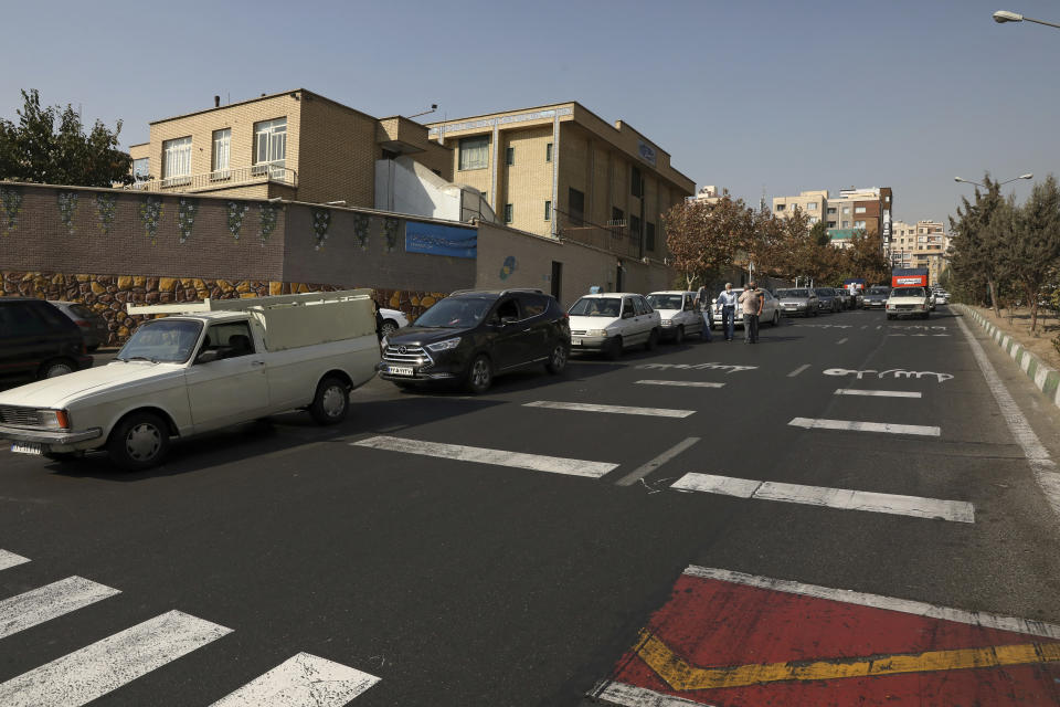 Cars wait in line to fill up at a gas station because pumps machines are out of service, in Tehran, Iran, Tuesday, Oct. 26, 2021. Gas stations across Iran on Tuesday suffered a widespread outage of a system that allows consumers to buy fuel with a government-issued card, stopping sales. One semiofficial news agency referred to the incident as a cyberattack. (AP Photo/Vahid Salemi)