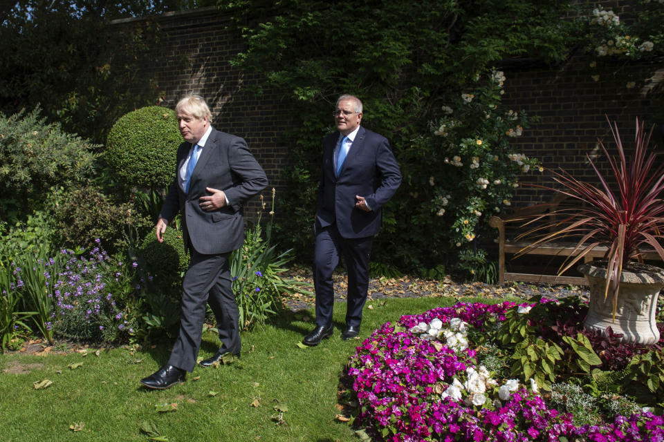 Britain's Prime Minister Boris Johnson, foreground, walks with Australian Prime Minister Scott Morrison after their meeting, in the garden of 10 Downing Streeet, in London, Tuesday June 15, 2021. Britain and Australia have agreed on a free trade deal that will be released later Tuesday, Australian Trade Minister Dan Tehan said. (Dominic Lipinski/Pool Photo via AP)