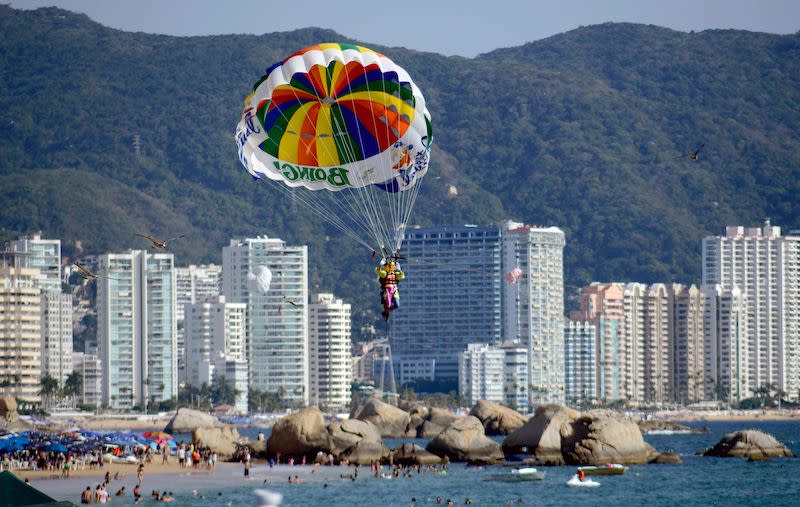 A man flies in a water parachute in Acapulco, Mexico, on Jan. 5, 2019. Despite being called Mexico’s murder capital, more than three-quarters of hotels were reportedly occupied over the holidays in Acapulco. Photo from Getty Images.