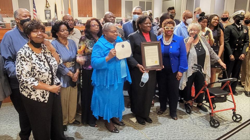 Cynthia Byrd Conner (center) stands with family and friends after receiving Councilwoman Ju'Coby Pittman's (right) resolution honoring her late father, Master Chief Boatswain’s Mate Sherman Byrd, during Tuesday's Jacksonville City Council meeting. He was the first Black explosive ordnance disposal technician in the U.S. Navy.