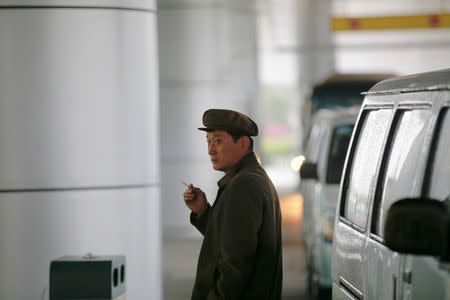 A man smokes a cigarette outside the airport in Pyongyang, North Korea May 3, 2016. REUTERS/Damir Sagolj