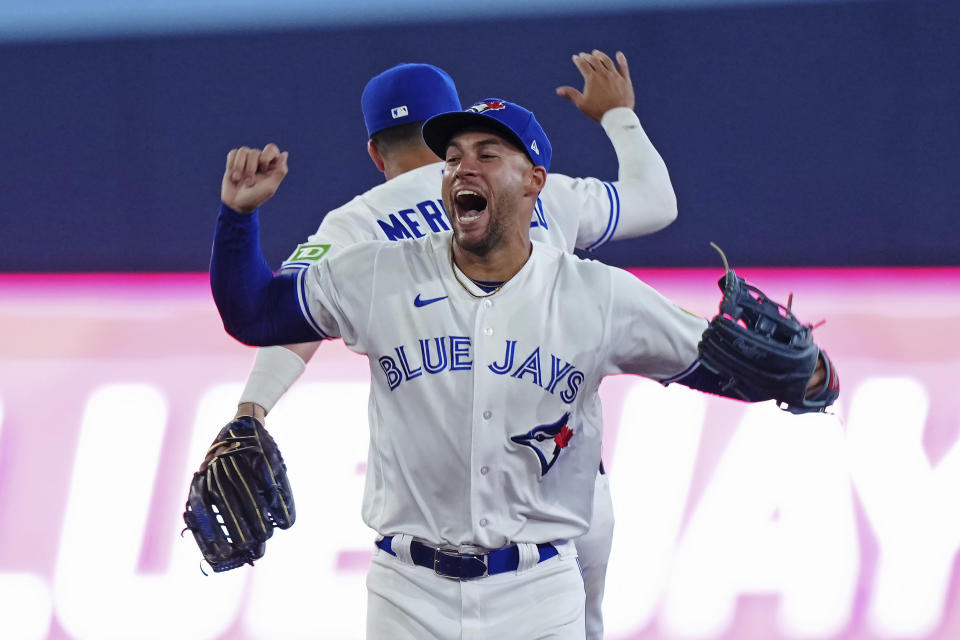 Toronto Blue Jays' George Springer, front, and Whit Merrifield celebrate the team's win over the Philadelphia Phillies in a baseball game Tuesday, Aug. 15, 2023, in Toronto. (Nathan Denette/The Canadian Press via AP)