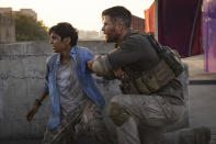 Chris Hemsworth, izquierda, y Rudhraksh Jaiswal en una escena de "Extraction" en una imagen proporcionada por Netflix. (Jasin Boland/Netflix via AP)